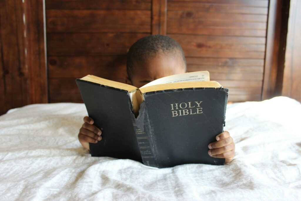 Little boy reading the bible